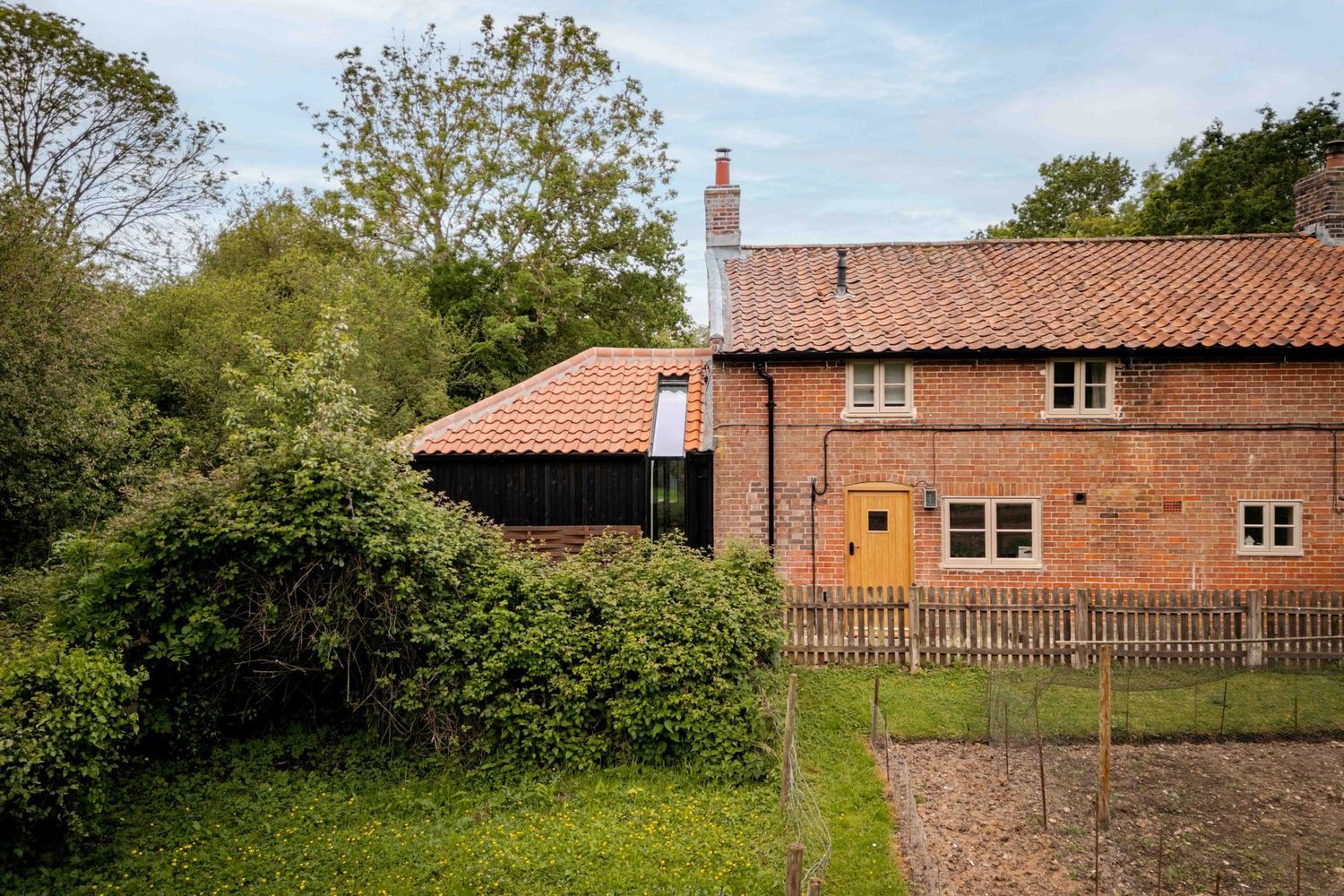 A restored brick cottage in its countryside setting