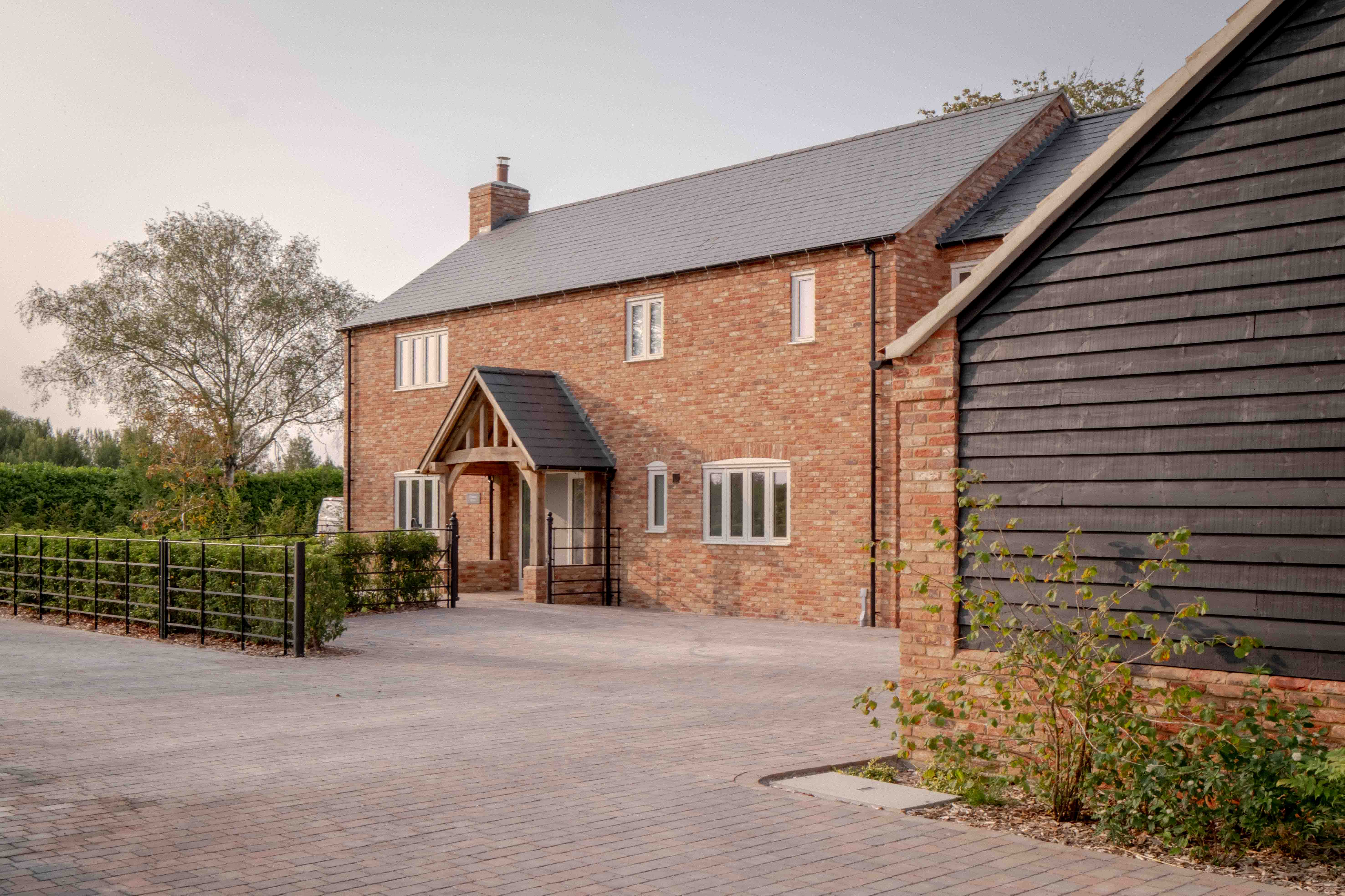 A finished home and its oak porch, with the yard behind