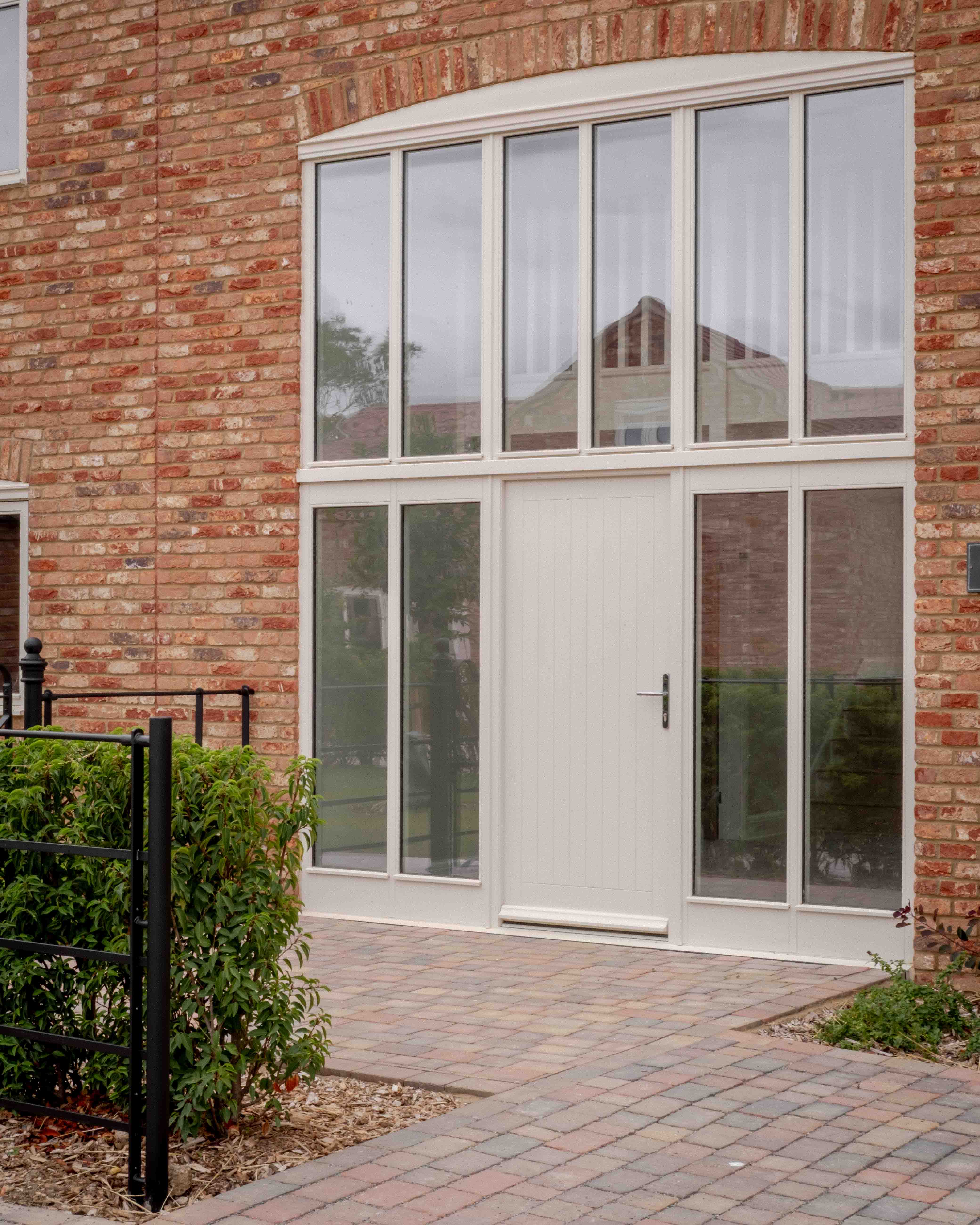 Glazed front door set into an arched brick opening, Blackberry Barn