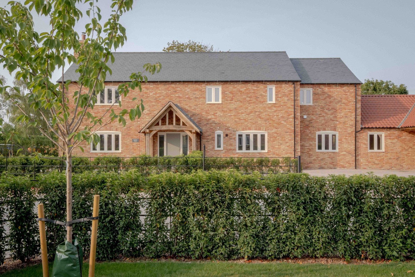 Chestnut House behind its new hedge, with an oak porch