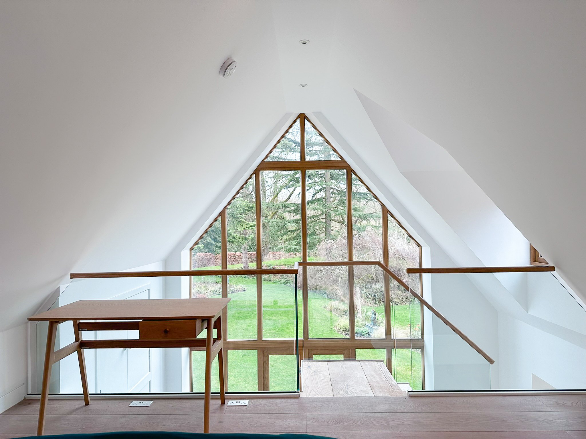 The finished mezzanine in the annexe, looking out through the tall glazed gable to the garden